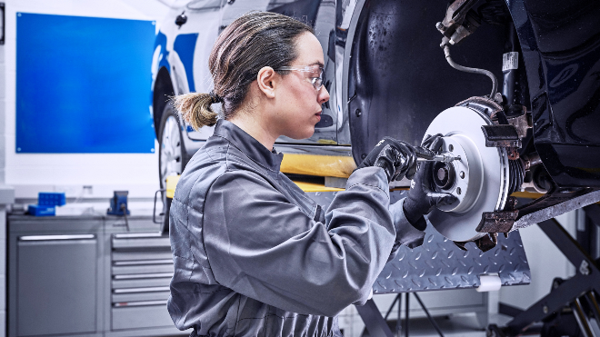 Delphi Expert replacing the front disks and brake pads of a raised vehicle.